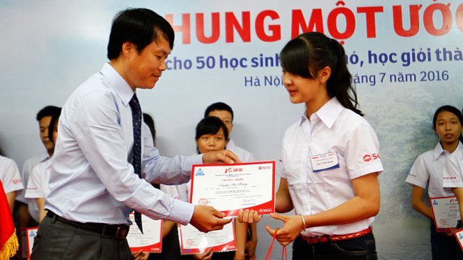 Ông Hồ Thanh Vinh, đại diện Tuổi Trẻ trao giấy chứng nhận cho các em học sinh - Ảnh: NAM TRẦN