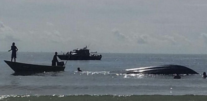 Lực lượng cứu hộ tại vị trí chiếc tàu bị lật - Ảnh: AFP