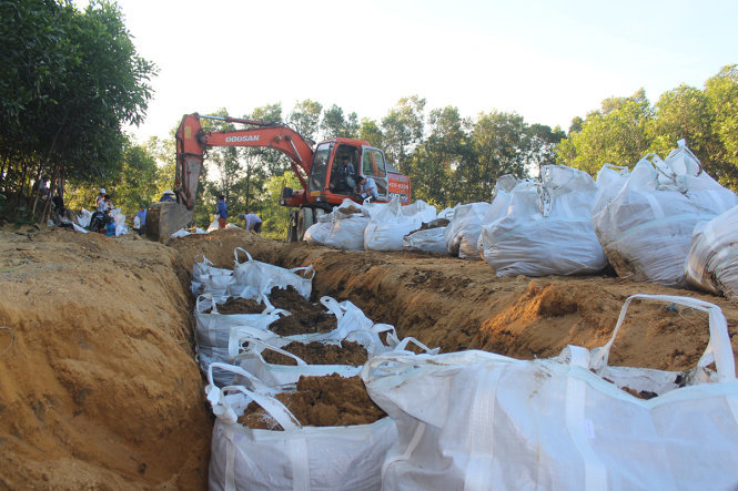 Công nhân môi trường đào hơn 100 tấn chất thải của Formosa chôn tại trang trại của ông Lê Quang Hòa, giám đốc Công ty Môi trường đô thị thị xã Kỳ Anh, để đưa về kho lưu trữ chờ xử lý - Ảnh: HỒ VĂN