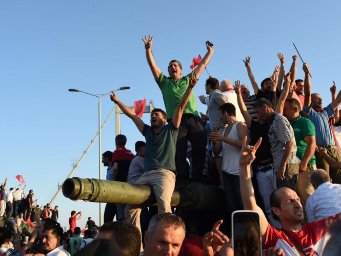 Người dân trèo lên chiếc xe tăng sau khi cuộc đảo chính của một nhóm người bị dập tắt tại Istanbul - Ảnh: AFP