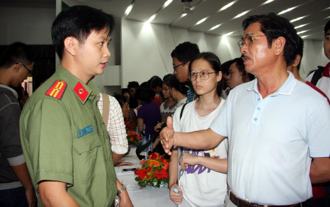 Thiếu tá Nguyễn Văn Trường đang giải đáp thắc mắc của thí sinh, phụ huynh tại Ngày hội tư vấn xét tuyển ĐH, CĐ năm 2016 do báo Tuổi Trẻ tổ chức - Ảnh : TRẦN HUỲNH