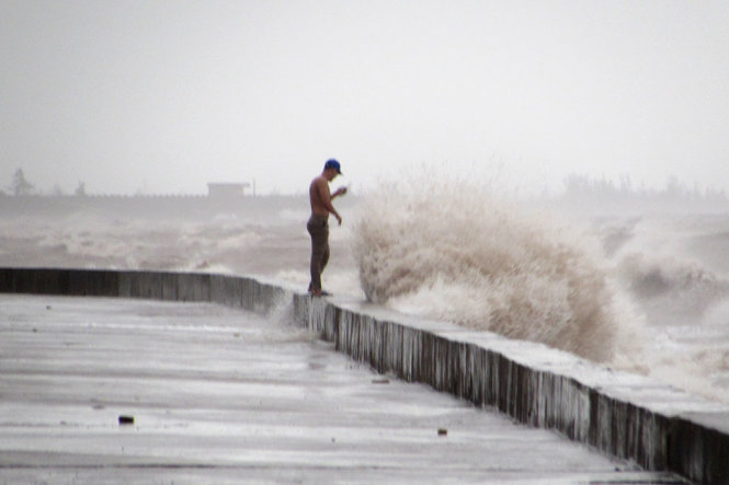 Chiều 27-7 tại vùng biển Quất Lâm, thị trấn Quất Lâm, huyện Giao Thủy, người dân bất chấp sóng lớn ra tại bãi biển ngóng tình hình cơn bão số 1