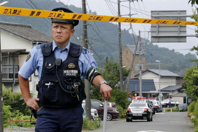 Một cảnh sát phong tỏa con đường dẫn vào trung tâm khuyết tật Sagamihara sau vụ thảm sát - Ảnh: EPA