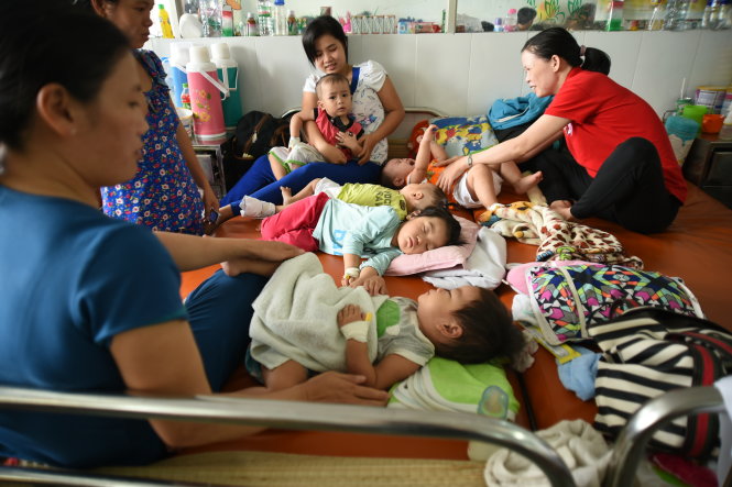 Các bé điều trị tại khoa hô hấp Bệnh viện Nhi Đồng 1 TP.HCM đang phải nằm chen chúc trên giường bệnh - Ảnh: HỮU THUẬN