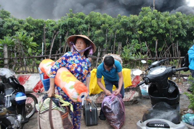 Công nhân ở 12 phòng trọ kết bên hoảng loạn bâng vội những đồ đạc có giá trị chạy ra ngoài đứng lo lắng - Ảnh: ĐÌNH TRỌNG