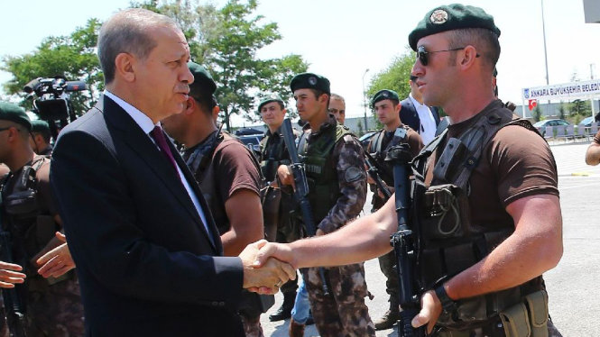 Tổng thống Thổ Nhĩ Kỳ Recep Tayyip Erdogan bắt tay với một cảnh sát tại thủ đô Ankara - Ảnh: AFP