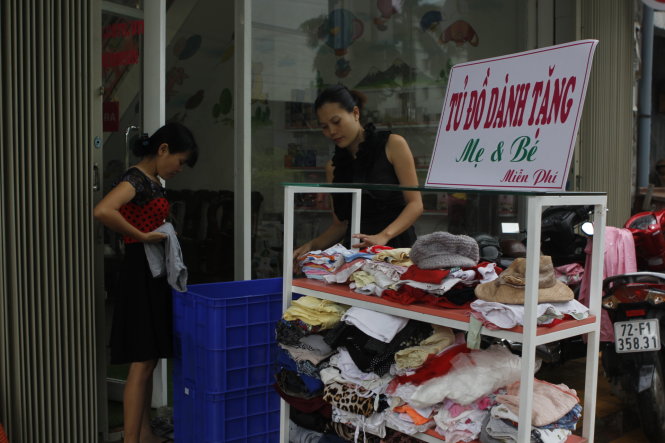 Chị Lê Huyền Trang (phải) sắp xếp tủ đồ miễn phí của mình - Ảnh: THÀNH NHÂN