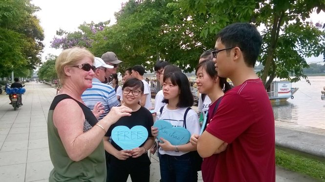 Một nhóm sinh viên, học sinh Huế trò chuyện với du khách nước ngoài - Ảnh: AMA Huế