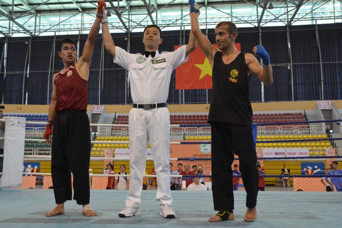 Trọng tài tuyên bố Detsada Pasansouk (Lào, trái) và Yaser Pormehr (Iran) cùng giành chiến thắng ở hạng cân 50 kg. Ảnh: Hắc Long.