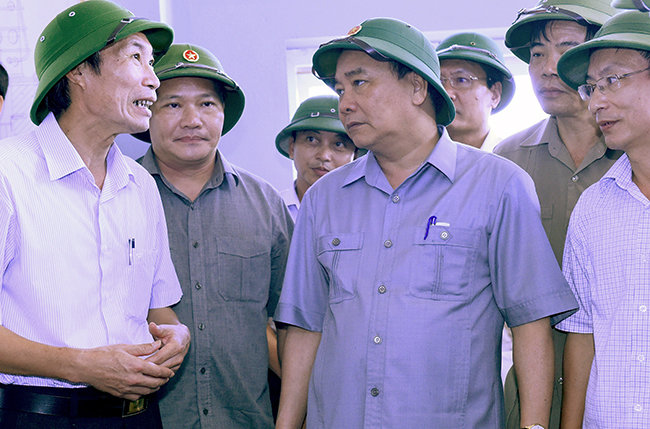 Lãnh đạo tỉnh Nam Định báo cáo Thủ tướng Nguyễn Xuân Phúc về việc vận hành bơm tiêu úng tại Trạm bơm Cốc Thành. Ảnh: VGP/Đức Tuân