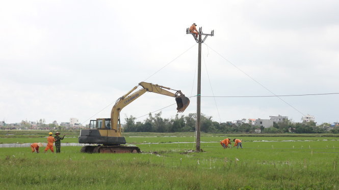 Công nhân khắc phục đường điện bị hư hỏng do bão số 1 gây ra tại thành phố Thái Bình - Ảnh: Tiến Thắng