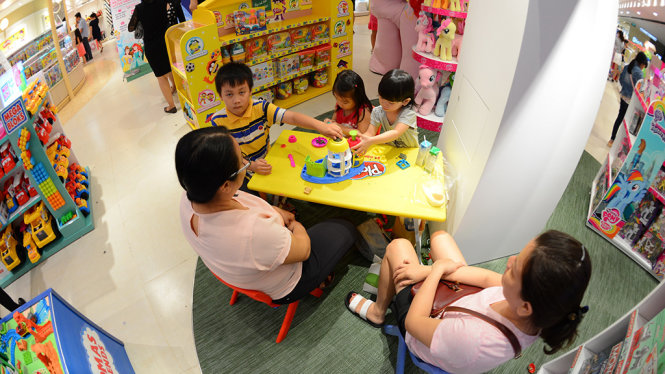 Trẻ em vui chơi trong trung tâm thương mại SaiGon Center tối 1-8 - Ảnh: Quang Định