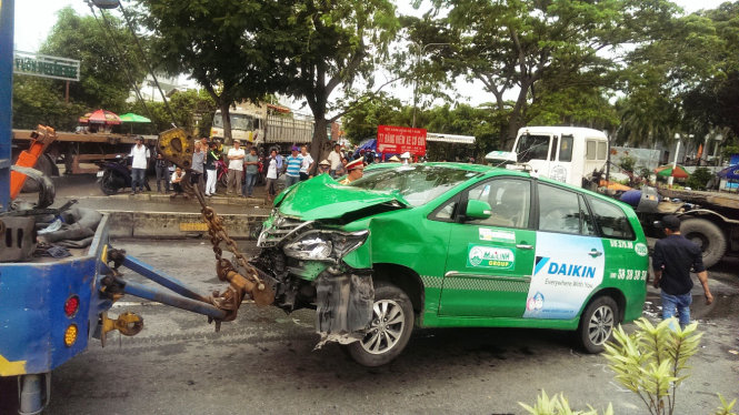 Một chiếc taxi bị nạn được cứu hộ đưa khỏi hiện trường - Ảnh: TÂM ĐỨC