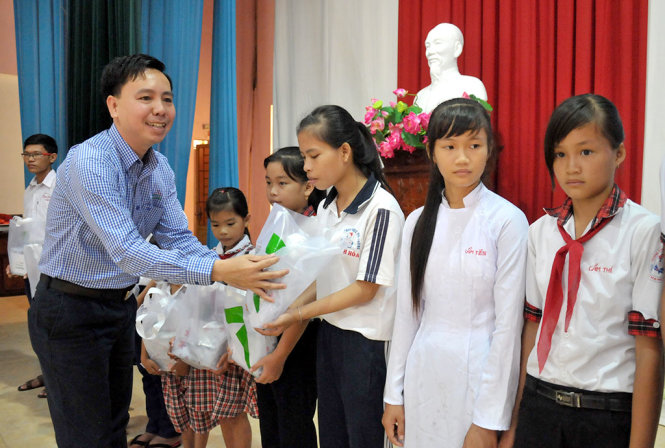 Ông Nguyễn Văn Truyền (áo sọc), giám đốc điều hành Công ty cổ phần Greenfeed Việt Nam  trao thưởng cho các em học sinh huyện Tân Thạnh - Ảnh  THANH TÚ