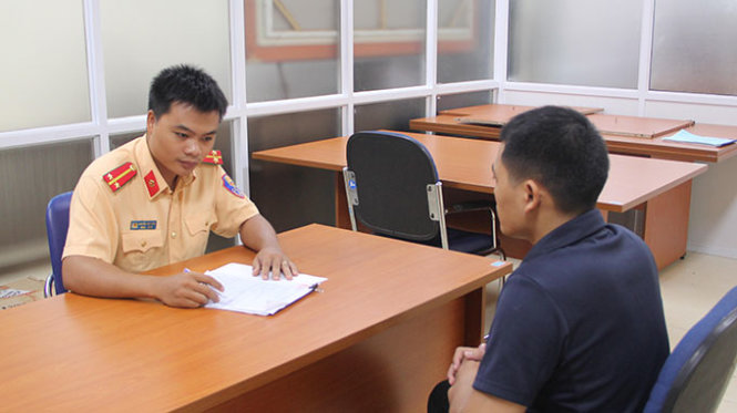 Cán bộ CSGT làm việc với anh T. để ra biên bản xử phạt hành vi để con trai 6 tuổi điều khiển xe máy - Ảnh Phòng CSGT Công an Hà Nội cung cấp