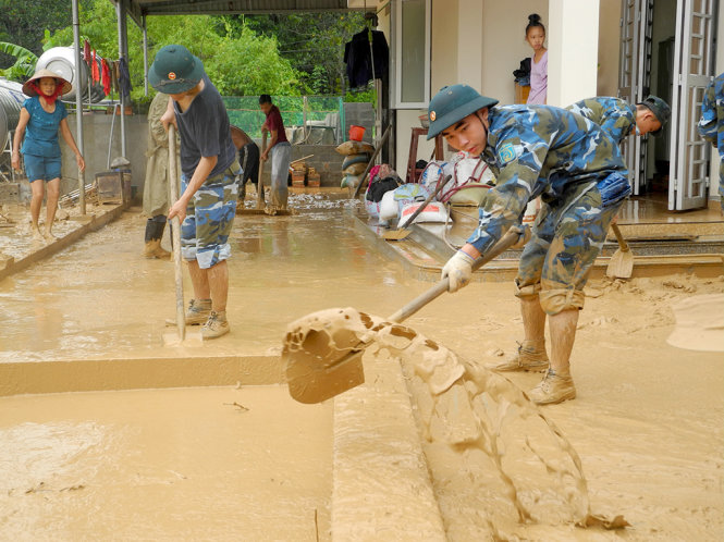 Các chiến sĩ Lữ đoàn 170 Hải quân giúp dân dọn dẹp bùn đất tràn vào sân, nhà  - Ảnh: ĐỨC HIẾU