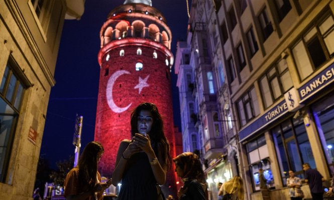 Một phụ nữ đang dùng điện thoại tại Istanbul - Ảnh: AFP