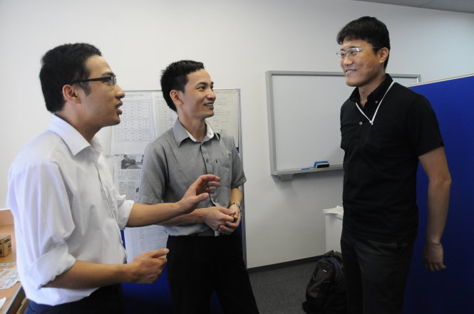 Anh Đỗ Văn Minh (trái) và anh Bùi Thế Dương (giữa) trao đổi với một học viên Nhật Bản Ảnh: TẤN VŨ