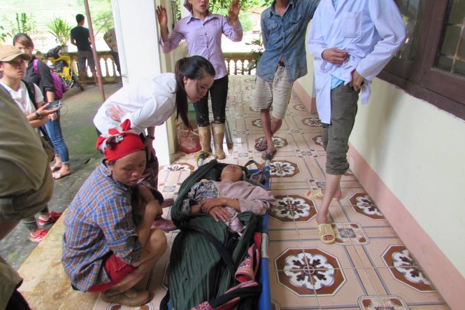 Bà Mẩy bị nước lũ cuốn trôi được người dân cáng vào trạm y tế xã - Ảnh: Hà Thanh