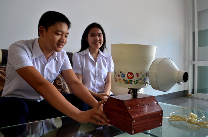 Đào Công Lương và Lưu Kiều Diễm bên chiếc máy bắn bóng bàn do hai em chế tạo - Ảnh: DUY THANH