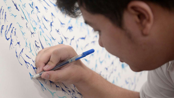 Chàng trai tự kỷ See Toh Sheng Jie vẽ hình khủng long - Ảnh: STRAITS TIMES