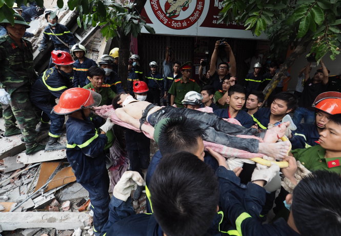 Một nạn nhân trong vụ sập nhà tại phố Cửa Bắc (Hà Nội) được lực lượng cứu hộ đưa ra khỏi đống đổ nát - Ảnh: NGUYỄN KHÁNH
