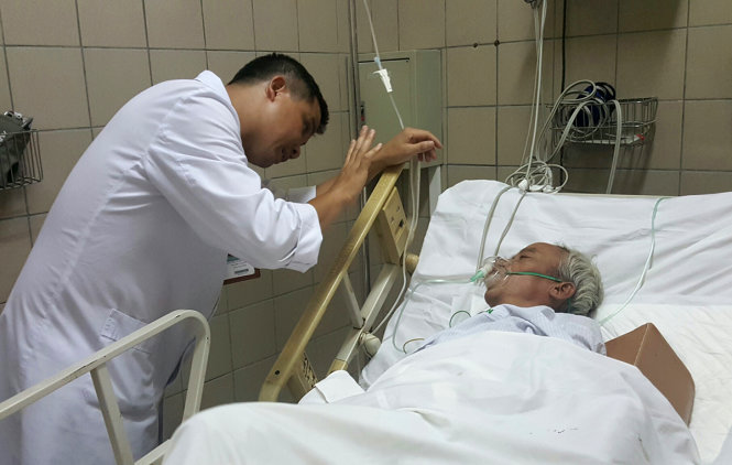 Bác sĩ Nguyễn Trung Nguyên (Trung tâm chống độc, BV Bạch Mai) khám cho bệnh nhân ngộ độc rượu do methanol - Ảnh: THÚY ANH
