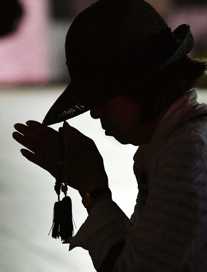 Một người phụ nữ cầu nguyện cho các nạn nhân tại đài tưởng niệm ở Công viên tưởng niệm hòa bình Hiroshima - Ảnh: AP