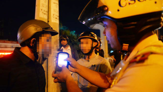 Cảnh sát giao thông kiểm tra nồng độ cồn một thanh niên đi xe máy trên xa lộ Hà Nội, Q.Thủ Đức, TP.HCM - Ảnh: Hữu Khoa