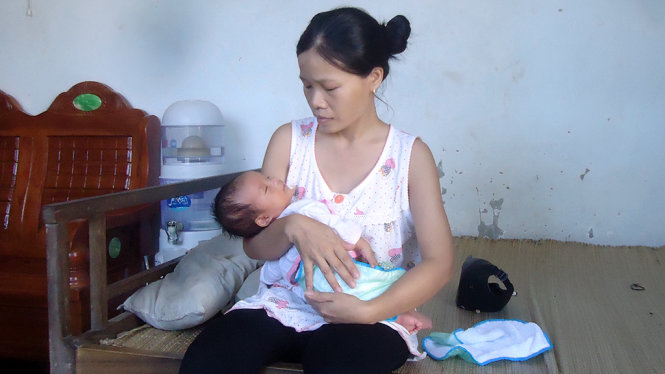 Bà Nguyễn Thị Oanh đang chăm sóc con nhỏ tại nhà - Ảnh: Hà Đồng