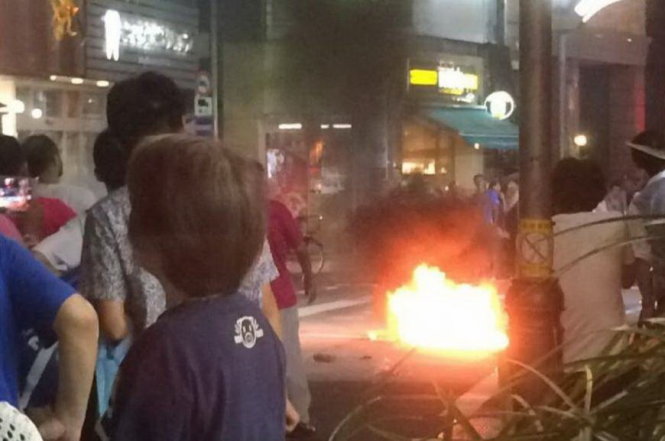Một chai bom xăng bốc cháy khi rơi xuống đường giữa lễ hội samba ở phường Suginami - Ảnh: Kyodo