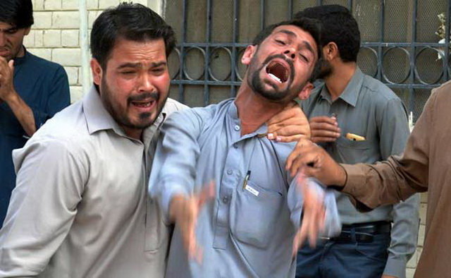 Người nhà các nạn nhân đau đớn trước cái chết của người thân trong vụ nổ - Ảnh: AFP