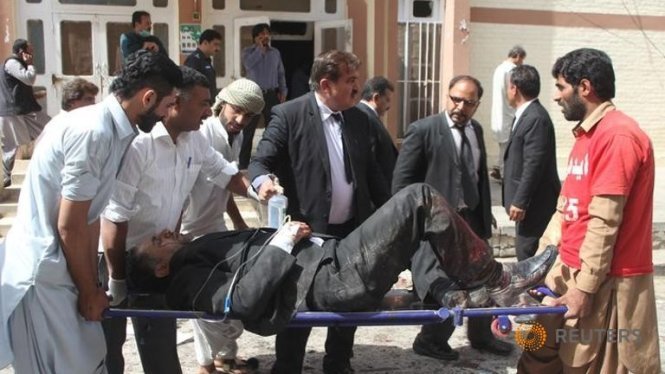 Những người tình nguyện cáng người bị thương khỏi hiện trường vụ đánh bom tại bệnh viện Quetta - Ảnh: Reuters