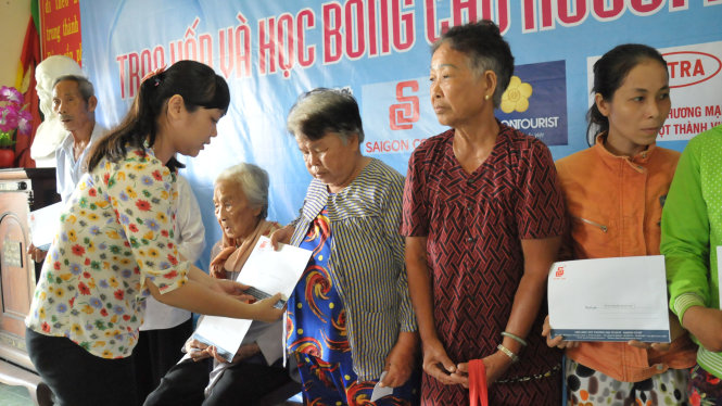 bà Nguyễn Thị Hương, UV Ban biên tập báo Tuổi Trẻ trao quà cho bà con nghèo xã Tân Phước
