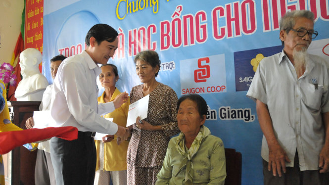 Ông Trương Minh Hậu, phó GĐ trung tâm xúc tiến du lịch, Sở Du lịch TP.HCM trao quà cho bà con nghèo xã Tân Phước