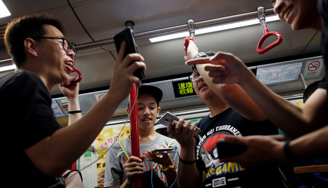 Người chơi Pokemon Go trên xe điện tại Hong Kong - Ảnh: REUTERS