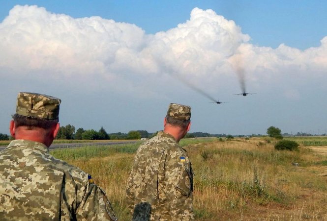 Các quân nhân Ukraine quan sát một chiếc Sukhoi Su-24 bay huấn luyện ở Rivne của Ukraine - Ảnh: Reuters