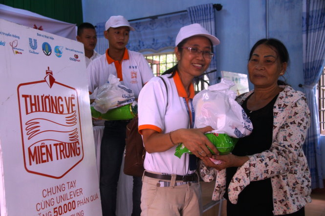 Một người dân (phải) tại thị trấn Phú Đa (huyện Phú Vang, tỉnh Thừa Thiên - Huế) nhận quà - Ảnh: NHẬT LINH