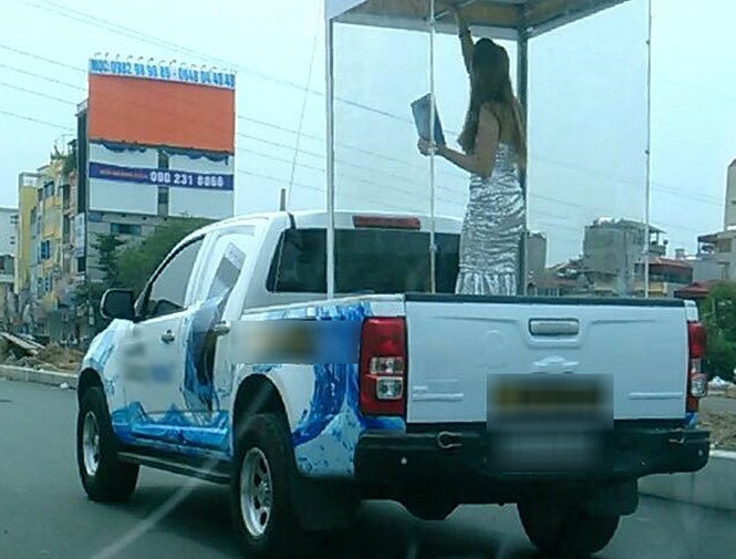Người mẫu được đưa vào lồng kính diễu phố quảng cáo cho mẫu điện thoại mới ra mắt - Ảnh tư liệu

