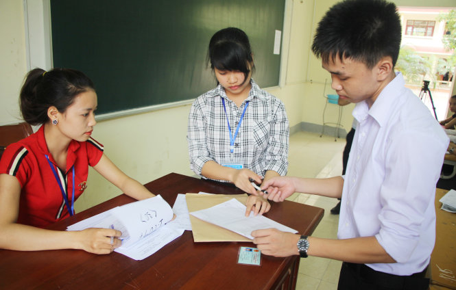 Thí sinh làm thủ tục vào phòng thi tại cụm thi Vinh - Ảnh: DOÃN HÒA