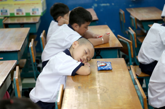 Tranh thủ ngủ của học sinh lớp 1 1 trường tiểu học Trần Bình Trọng Q5, TP.HCM trong ngày tựu trường - Ảnh: NHƯ HÙNG