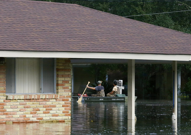 Người dân dùng thuyền bơi qua nước ngập ở giáo xứ Ascension, bang Louisiana - Ảnh: Reuters