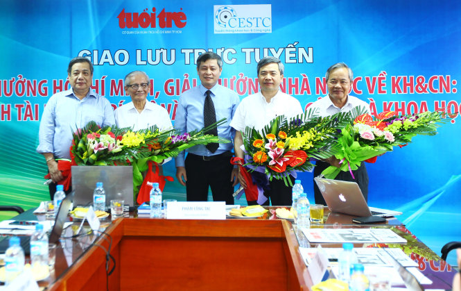 Thứ trưởng Bộ KH&CN Phạm Công Tạc (giữa) tặng hoa và chụp ảnh lưu niệm với các nhà khoa học tại buổi giao lưu trực tuyếN - Ảnh: NGUYỄN KHÁNH