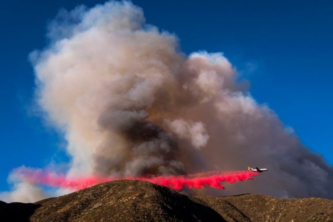 Một máy bay thả chất làm chậm cháy xuống đám cháy Blue Cut ở Lytle Creek, California - Ảnh: AFP