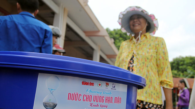 Người dân vùng nhiễm mặn xã Long Định, huyện Bìn Đại, tỉnh Bến Tre nhận thùng chứa nước để trữ nước mưa - Ảnh: Mậu Trường