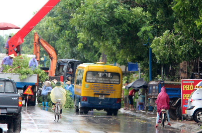 Lực lượng chức năng cắt cành cây xanh tại đường dẫn vào cao tốc Hà Nội - Hải Phòng sáng 19-8 - ẢNH: B.SƠN