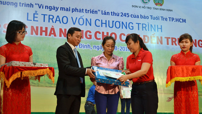 Bà Nguyễn Thị Hương (phải), ủy viên BBT báo Tuổi Trẻ (phải) và ông Lê Phước Tín, giám đốc kinh doanh Công ty CP GreenFeed VN chi nhánh Bình Định trao vốn cho nông dân nghèo - Ảnh: DUY THANH