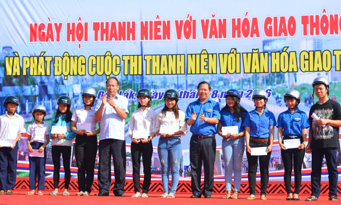 Đại diện Trung ương Đoàn TNCS Hồ Chí Minh và Ủy ban An toàn Giao thông quốc gia trao học bổng và mũ bảo hiểm đạt chuẩn cho học sinh có người thân bị tai nạn giao thông - Ảnh: LĨNH HỒNG