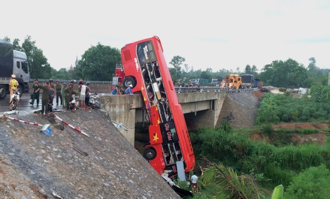 Chiếc xe khách treo lơ lửng trên thành cầu xuống mặt đất sau vụ tai nạn - Ảnh: L.P