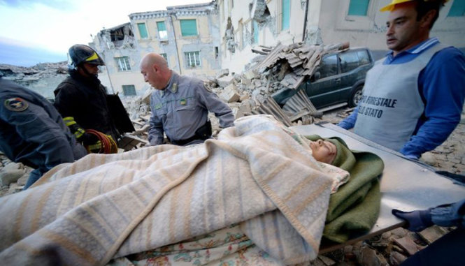 Một người được lực lượng cứu hộ đưa ra khỏi đống đổ nát - Ảnh: AFP